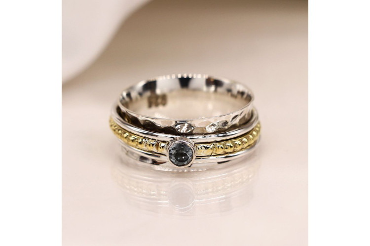 Sterling silver spinning ring with blue topaz on a brass band